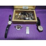 A small wooden jewellery box containing a selection of costume jewellery including wrist watches,