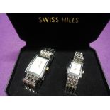 A cased pair of his and hers wrist watches by Swiss Hills