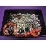 A box containing a selection of vintage and modern costume jewellery including strings of beads