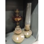 A selection of oil lamps including gold printed ruby glass well