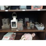 A shelf of various vintage railway and similar oil and parafin lamps with various spares