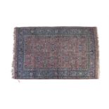 A SEMI ANTIQUE PERSIAN CARPET, the central reserve filled with flower heads and leafy sprays against