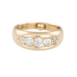 A GOLD FIVE-STONE DIAMOND RING, the plain band inset with five graduating old-cut diamonds,