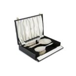 AN ART DECO SILVER THREE PIECE VANITY SET, Birmingham 1932, comprising hand mirror and brushes,
