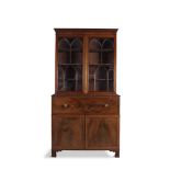 A GEORGE III FLAME MAHOGANY SECRETAIRE BOOKCASE, c. 1800, the upper section with lancet glazed doors