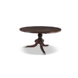 A REGENCY CROSSBANDED TILT-TOP BREAKFAST TABLE, the circular top raised on turned reeded centre