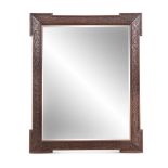 A PAIR OF ARTS AND CRAFTS CARVED WOOD MIRRORS, each fitted with bevelled glass plates, with