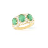 AN EMERALD AND DIAMOND DRESS RINGComposed of three oval-shaped emeralds at the centre, each within a