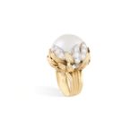 A CULTURED PEARL AND DIAMOND COCKTAIL RING, CIRCA 1955Designed as a stylised flowerhead, set at