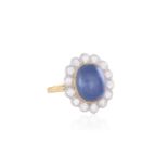 A SAPPHIRE AND DIAMOND CLUSTER RINGThe oval-shaped cabochon sapphire weighing approximately 8.