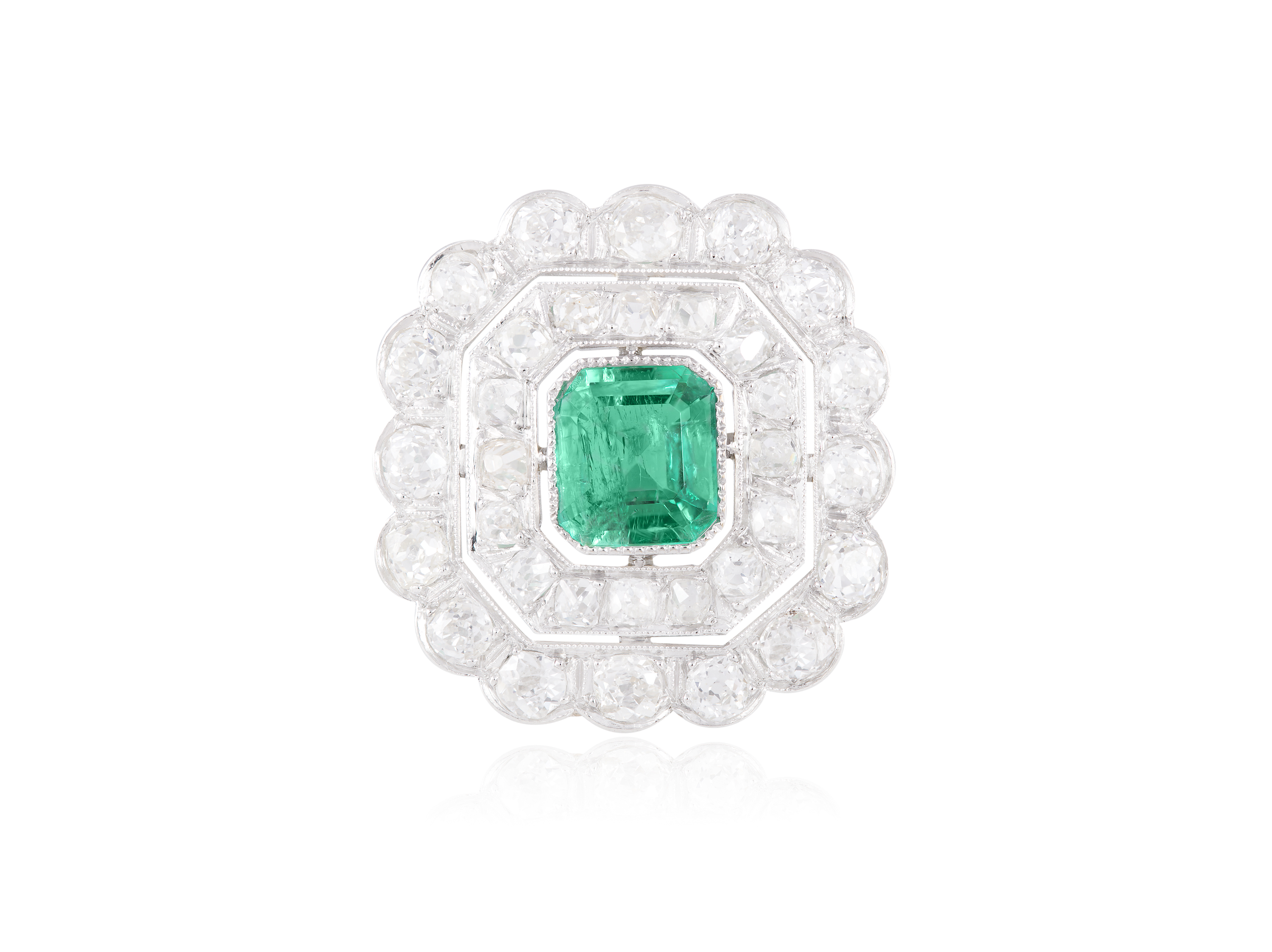 AN EARLY 20TH CENTURY EMERALD AND DIAMOND DRESS RINGThe cut-cornered rectangular-cut emerald