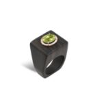 AN GEM-SET AND EBONY DRESS RINGThe central oval-shaped mixed-cut peridot within a frame of round