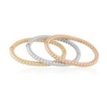 A TRIO OF GOLD BANGLE BRACELETSComposed of three hinged gold bracelets with twisted reeded