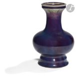 CHINE - XIXe siècle Vase à panse basse sur piédouche en porcelaine émaillée aubergine flammée. H.