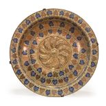 Plato historicista en forma de brasero de cerámica esmaltada con umbo central y hojas de parra y