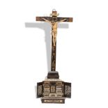 “Cristo” Figura de marfil, con toques de policromía y oro, sobre pequeño cabinet en madera ebonizada
