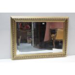 A large rectangular wall mirror in gilt & black-finish frame, & inset bevelled plate, 30” x 42”.