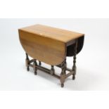 A 1930’s oak gate-leg dining table with moulded edge & rounded corners to the rectangular top, &