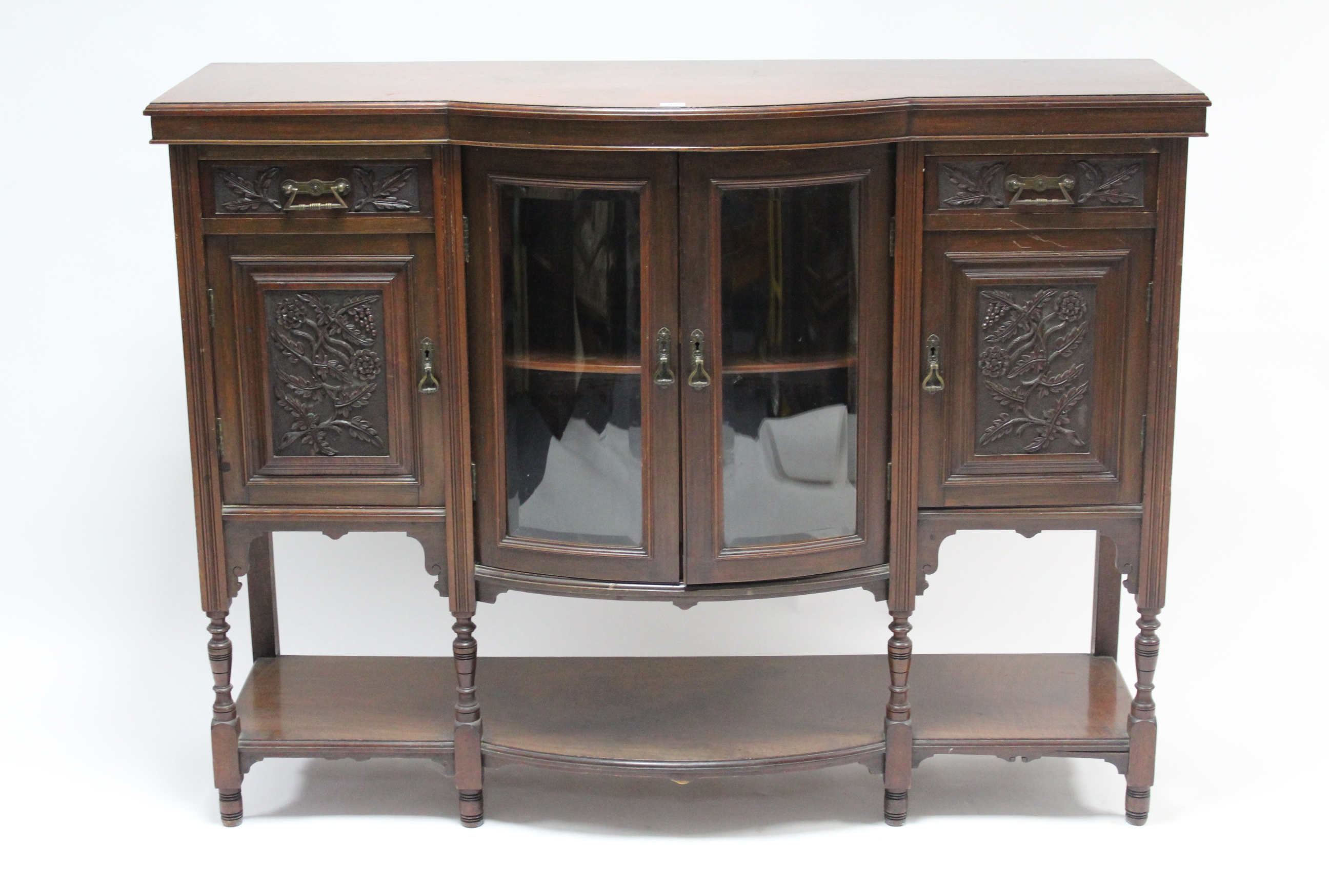 A late Victorian Jas. Schoolbred & Co. mahogany bow-front side cabinet, with enclosed cupboard to