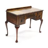 A walnut kneehole dressing table fitted three frieze drawers, & on slender cabriole legs & pad feet,