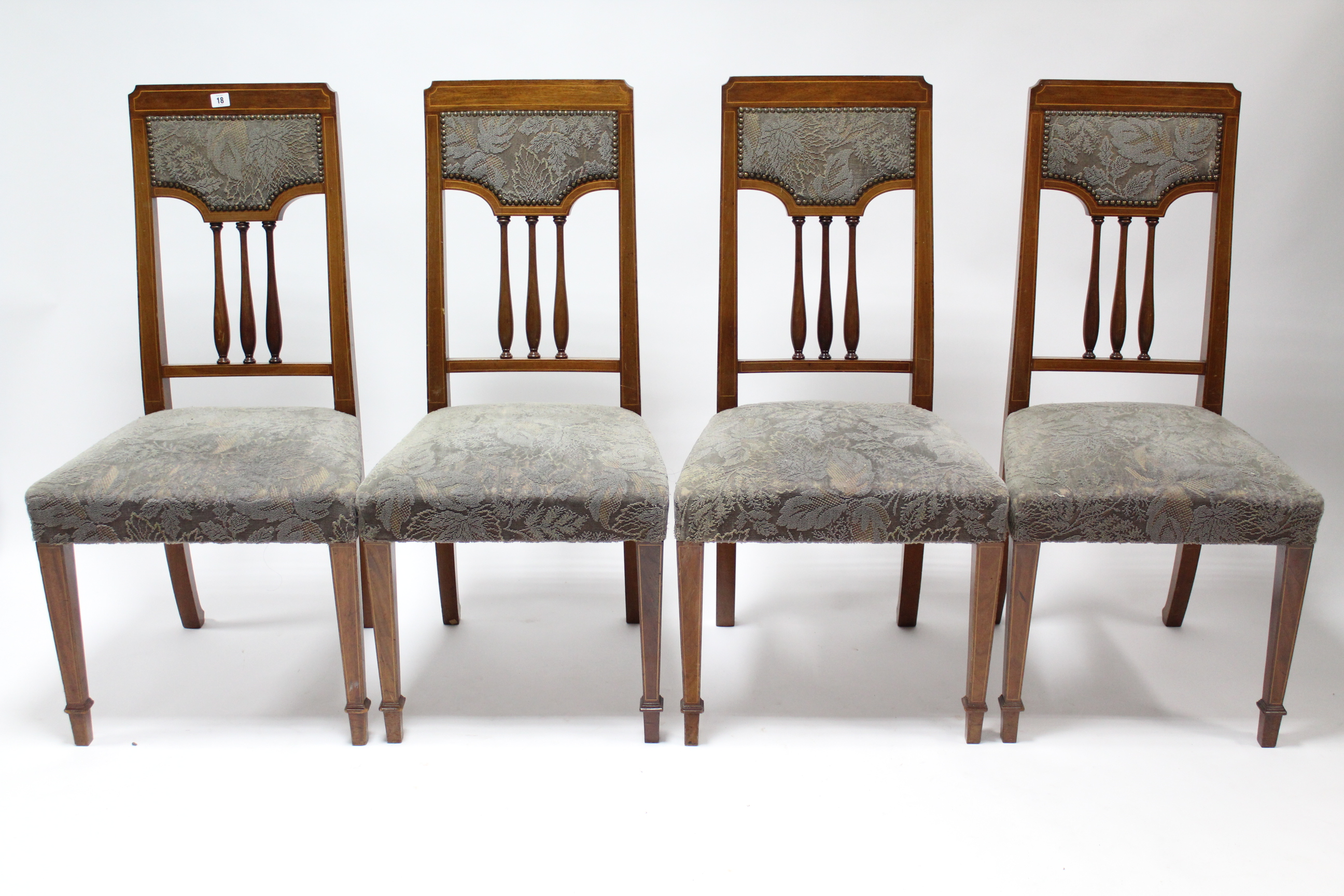 A set of four Edwardian inlaid-mahogany spindle-back dining chairs with sprung seats, & on square