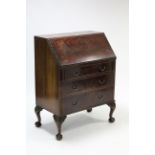 A Maple & Co. mahogany bureau with fitted interior enclosed by fall-front above three long graduated