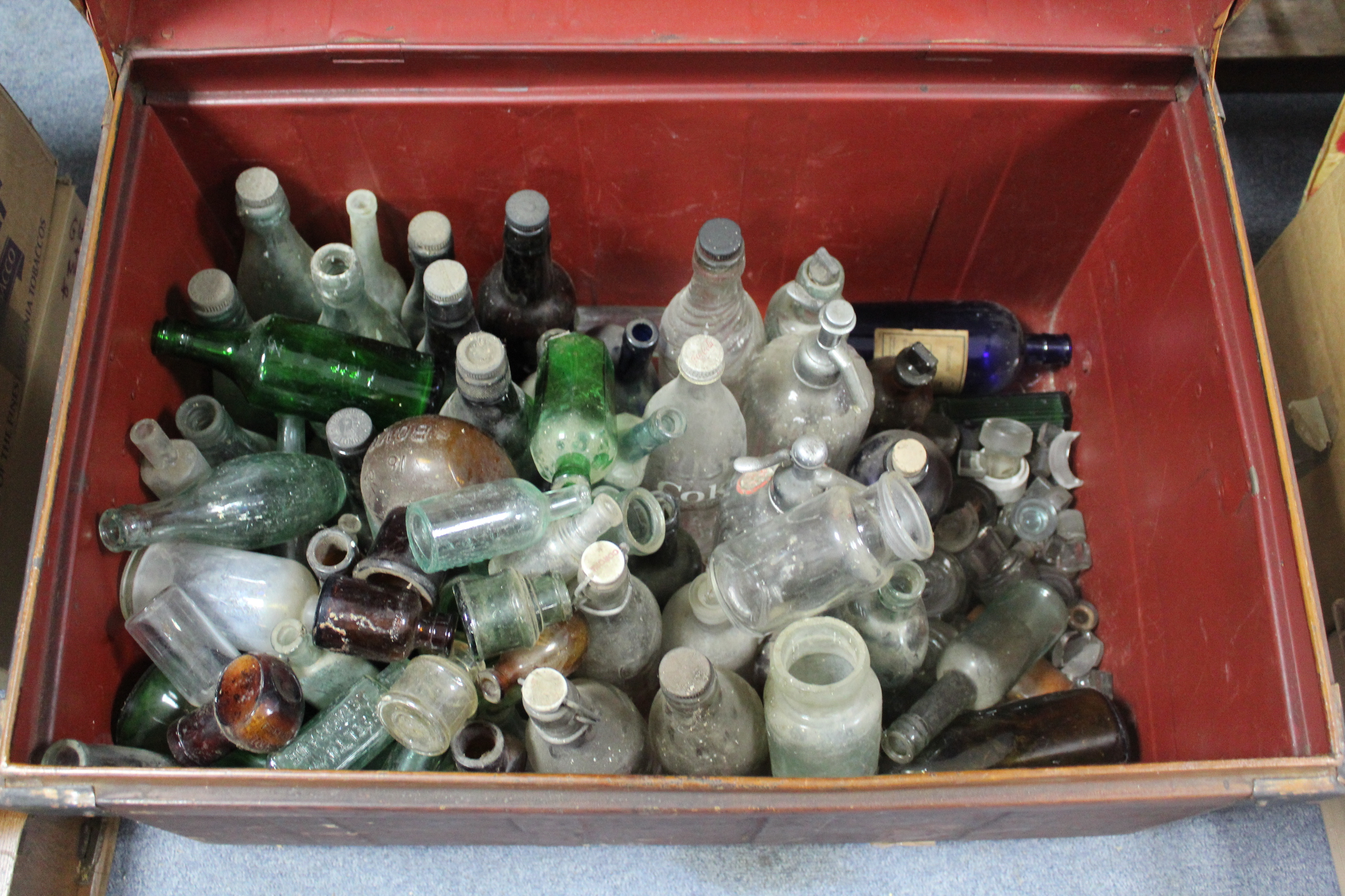 A collection of approximately eighty various bottles & jars; & a grained tin travelling trunk, 27”