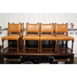 A set of eight oak dining chairs with padded seats & backs upholstered brown leatherette, & on