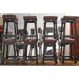 A set of eight bar stools with brass studded brown leatherette seats & on turned legs with plain
