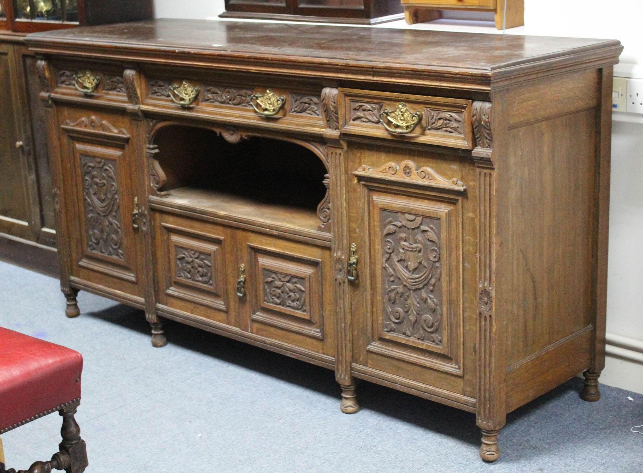 A late Victorian oak sideboard, fitted three frieze drawers above an open recess & two pairs of