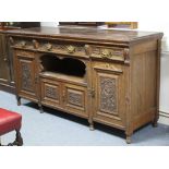 A late Victorian oak sideboard, fitted three frieze drawers above an open recess & two pairs of
