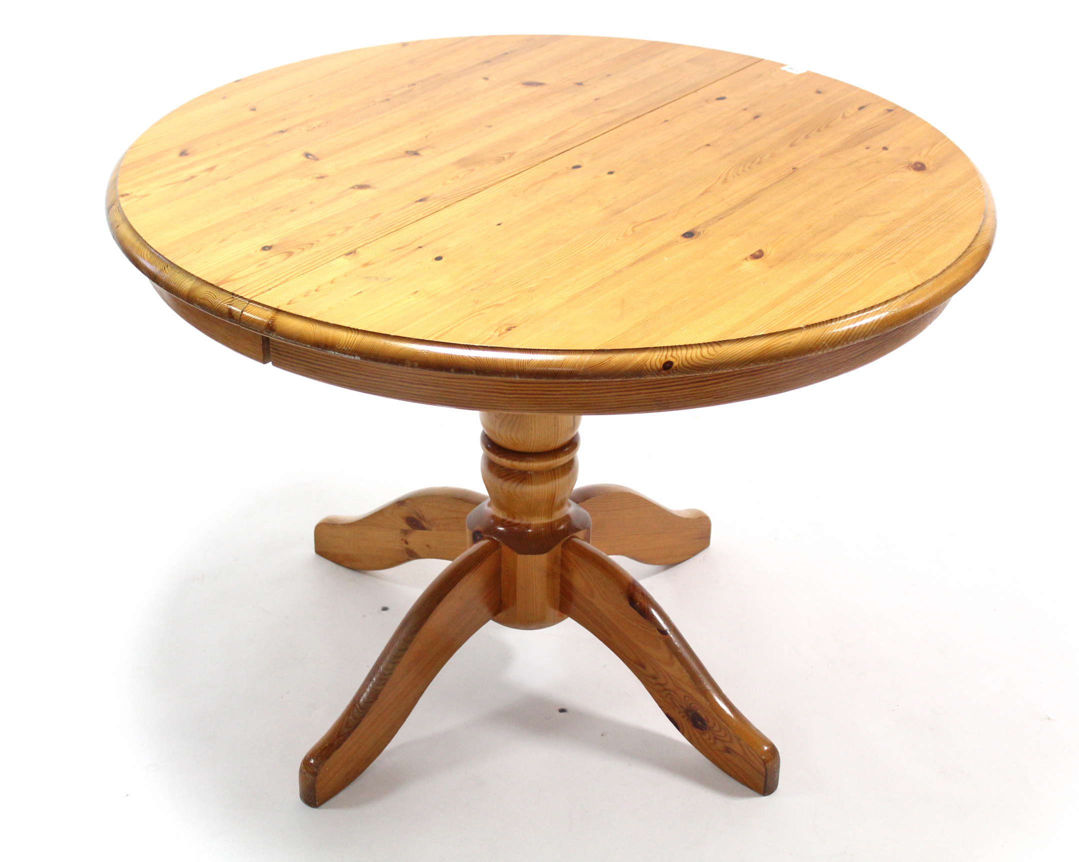 A pine pedestal dining table with circular top, & on vase-turned centre column & four splay legs,