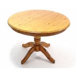 A pine pedestal dining table with circular top, & on vase-turned centre column & four splay legs,