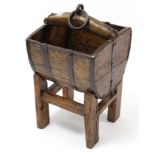 An iron-bound wooden wall bucket, 15½” wide, with stand.