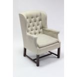 A Georgian-style buttoned-back armchair, upholstered cream material & on square legs with plain