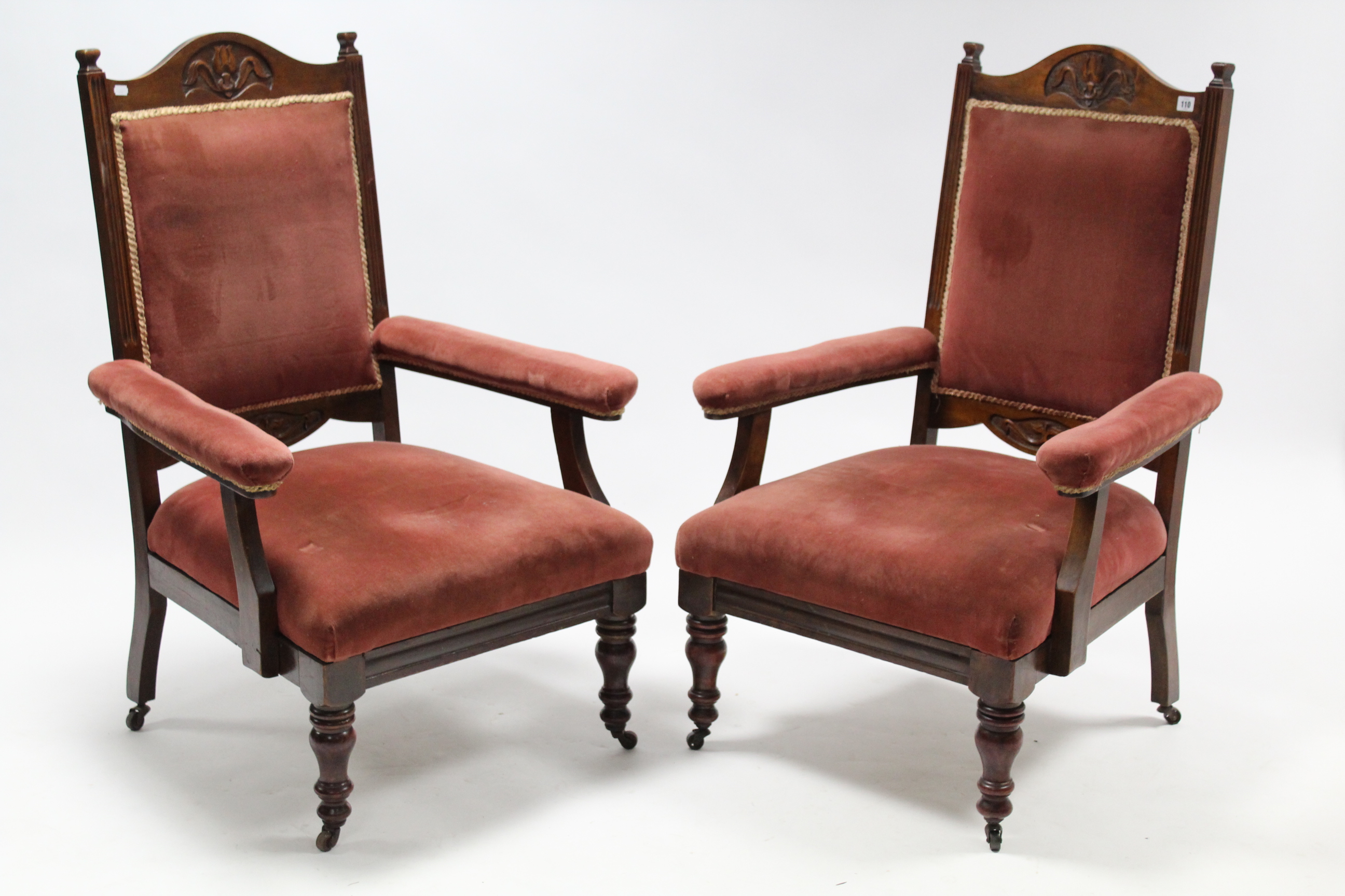 A pair of Edwardian carved walnut frame armchairs with padded back, arms, & sprung seats upholstered