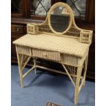 A wicker dressing table, inset oval mirror to the stage back, & fitted centre frieze drawer, 36¼”