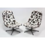 A pair of swivel easy chairs upholstered black & white floral material, & on chrome legs.