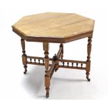 A late Victorian walnut centre table with octagonal top, & on four turned & fluted tapering legs,
