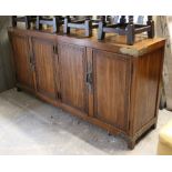 An oriental-style hardwood sideboard with fitted interior enclosed by two pairs of panel doors