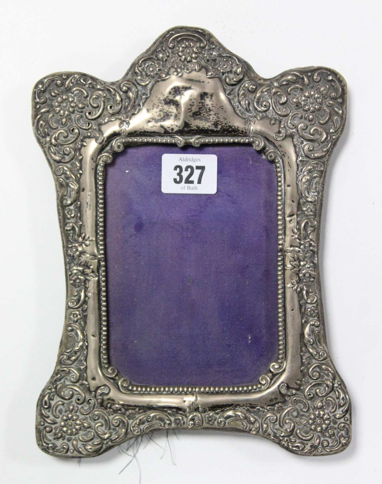 A silver embossed rectangular photograph frame on easel support, 9½” x 6¾” (hallmarks rubbed).