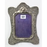 A silver embossed rectangular photograph frame on easel support, 9½” x 6¾” (hallmarks rubbed).