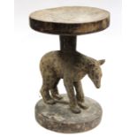 A Zimbabwean carved wooden stool, Tonga, the circular hard seat supported by a spotted hyena on