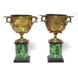 A pair of 19th century ormolu Roman-style urns, each with fruiting vine decoration, on malachite