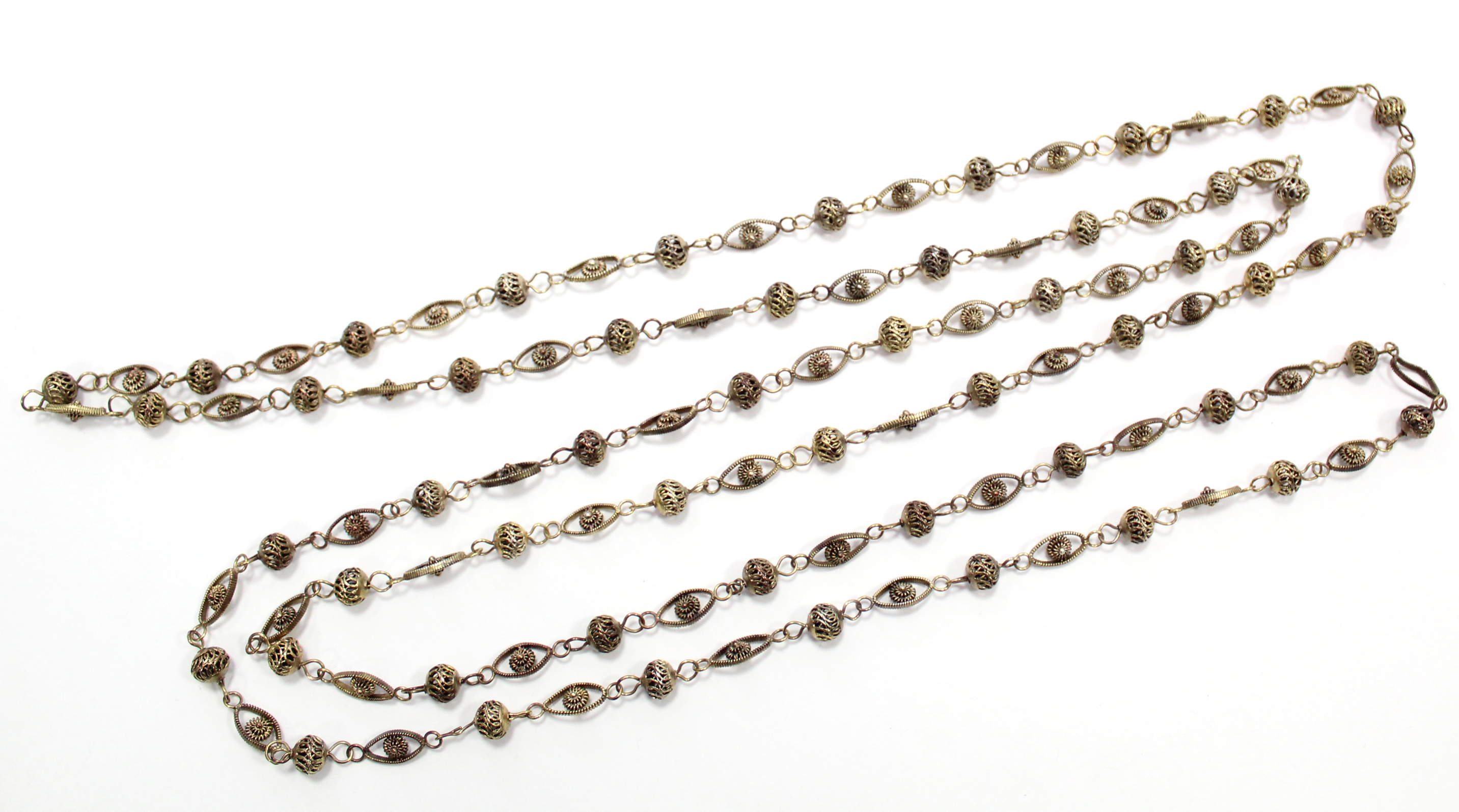 A silver-gilt long chain of alternating pierced ball & oval links.