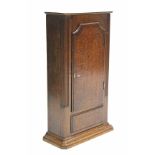 A late 18th century crossbanded oak narrow cupboard enclosed by a panel door; 31½” high x 19”