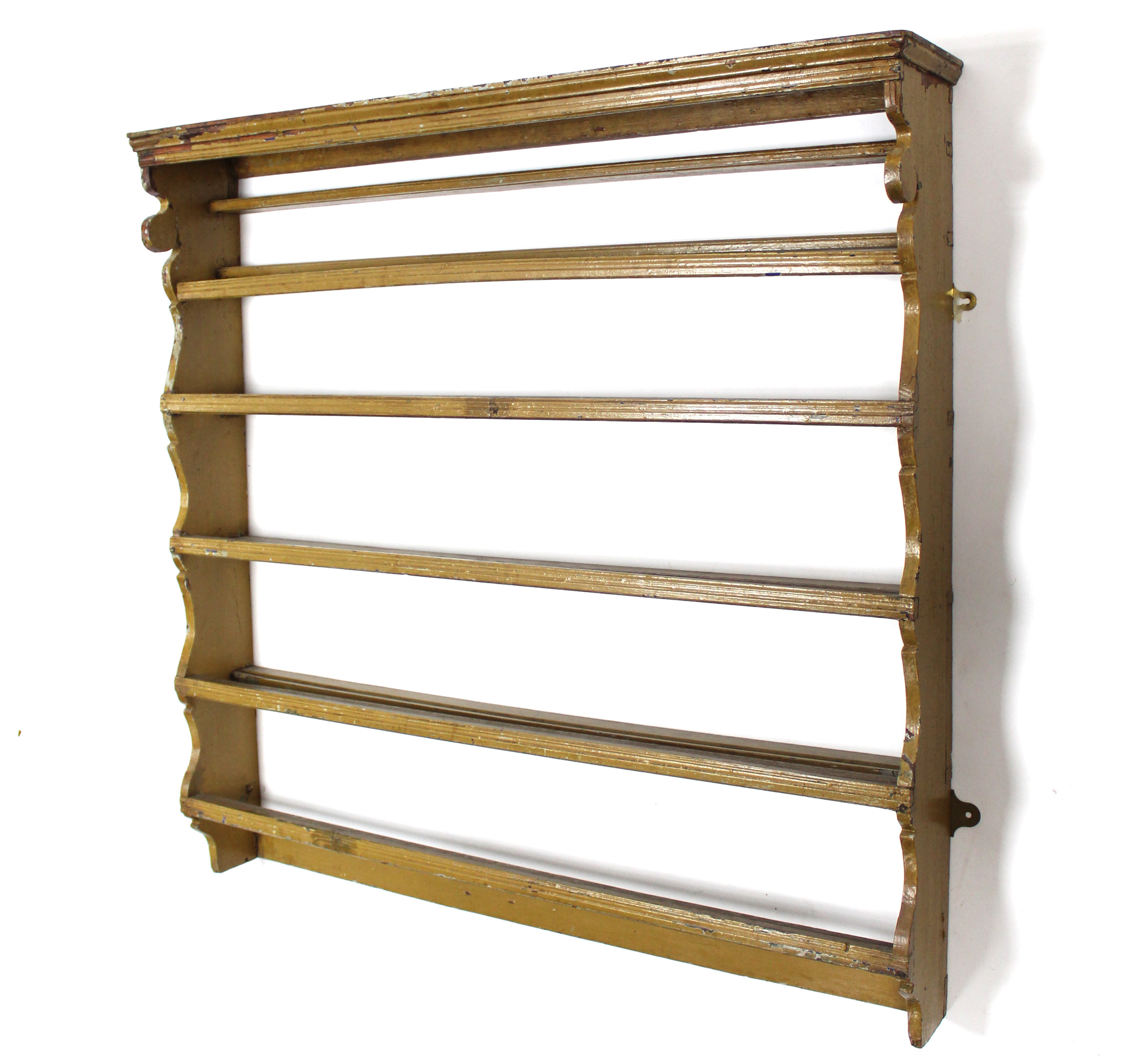 An early 18th century wall-mounted plate rack of three open shelves, painted in ochre, 40½” wide x