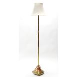 A brass standard lamp on fluted rise-&-fall column & circular base with bun feet; 66” high.