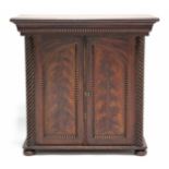 A 19th century grained pine “flame mahogany” table-top cabinet, with moulded cornice, enclosed by