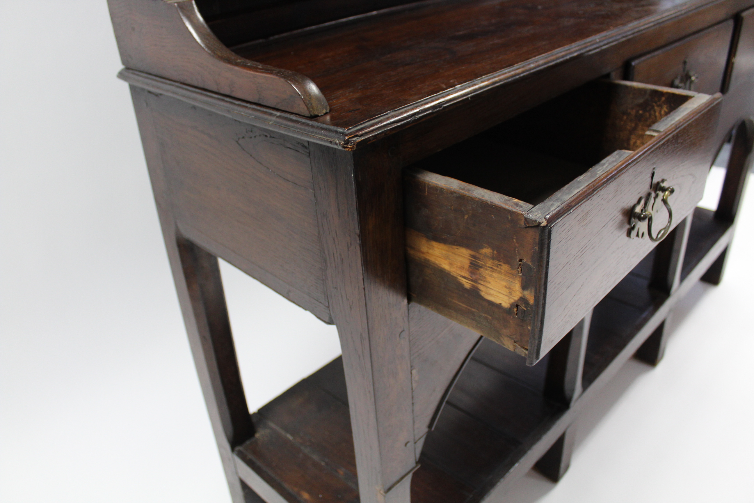 AN 18th century OAK DRESSER, fitted three shelves above three frieze drawers with shaped brass swing - Image 4 of 4